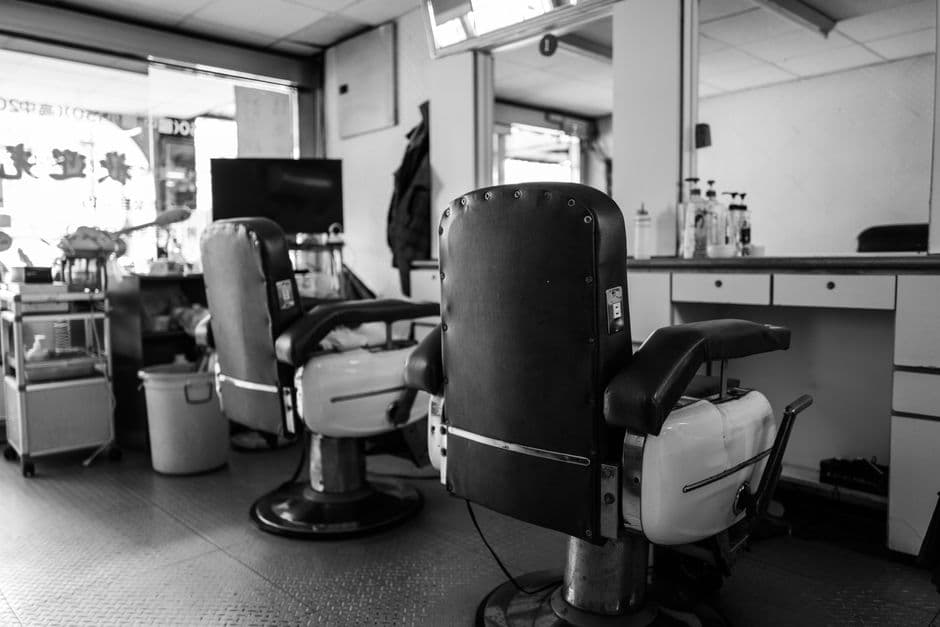 A vintage barbershop interior with classic barber chairs and mirrors in black and white.
