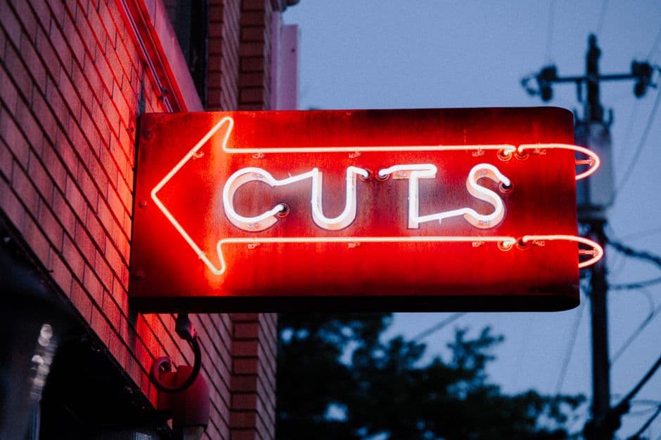 Red neon sign for a barbershop cuts through the evening sky in Durham, North Carolina.